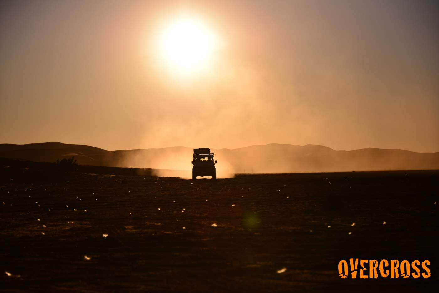 Sonnenuntergang mit Geländewagen auf einer Piste in Marokko