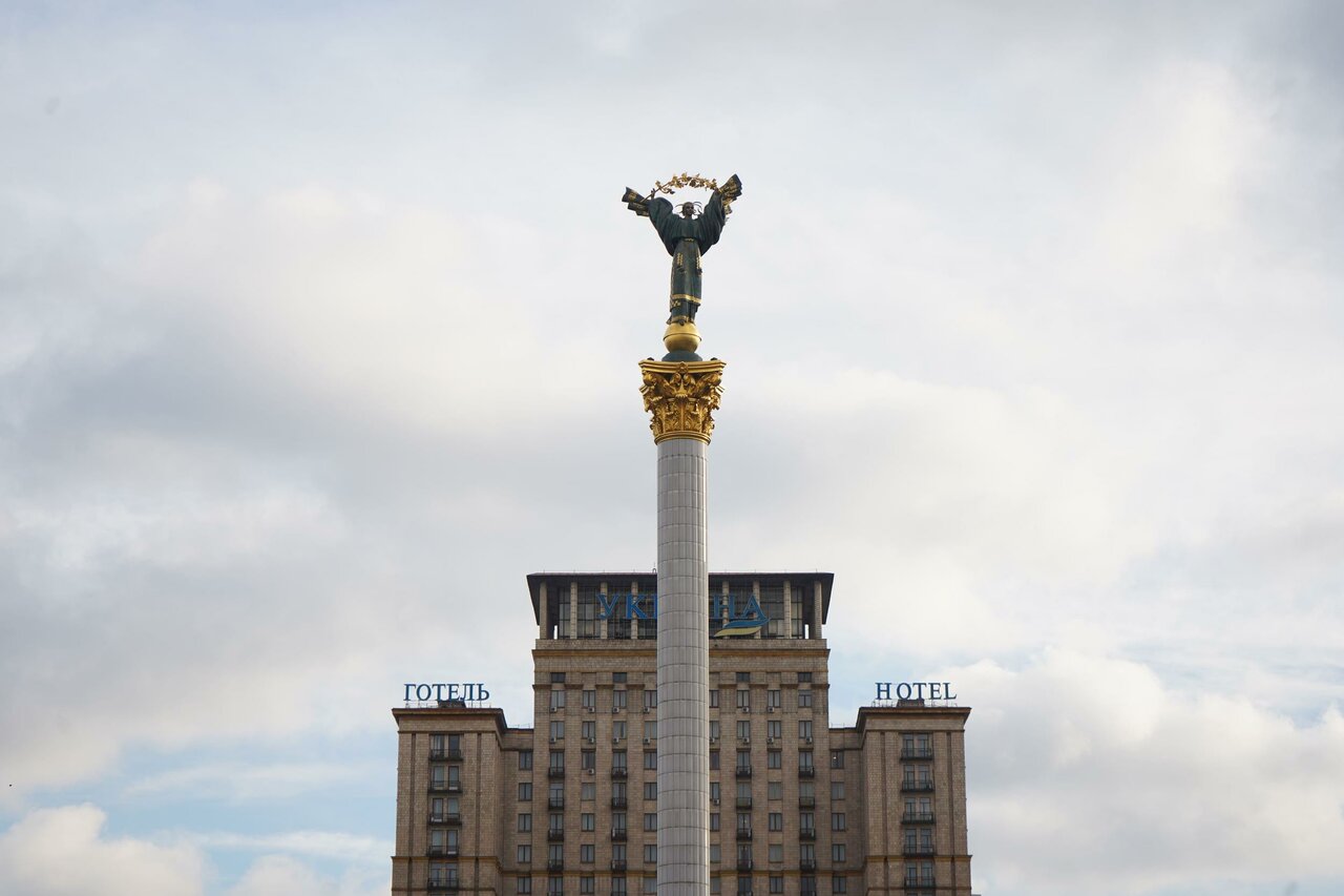 Die Säule des Unabhängigkeitsdenkmals in Kyjiw, dahinter das Gebäude des Hotel Ukraine