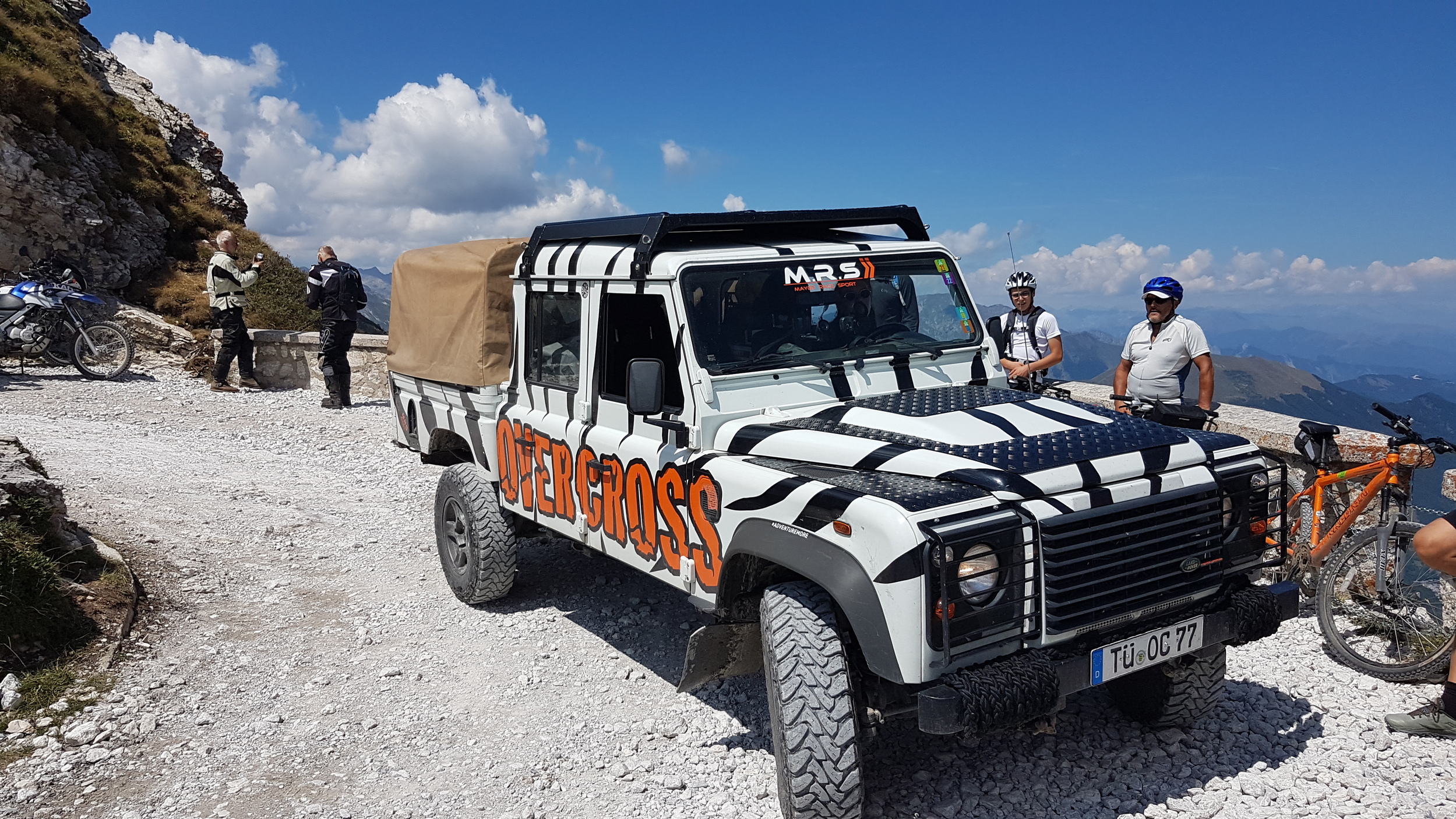 Ein Geländewagen auf einer Schotterstraße in den Westalpen