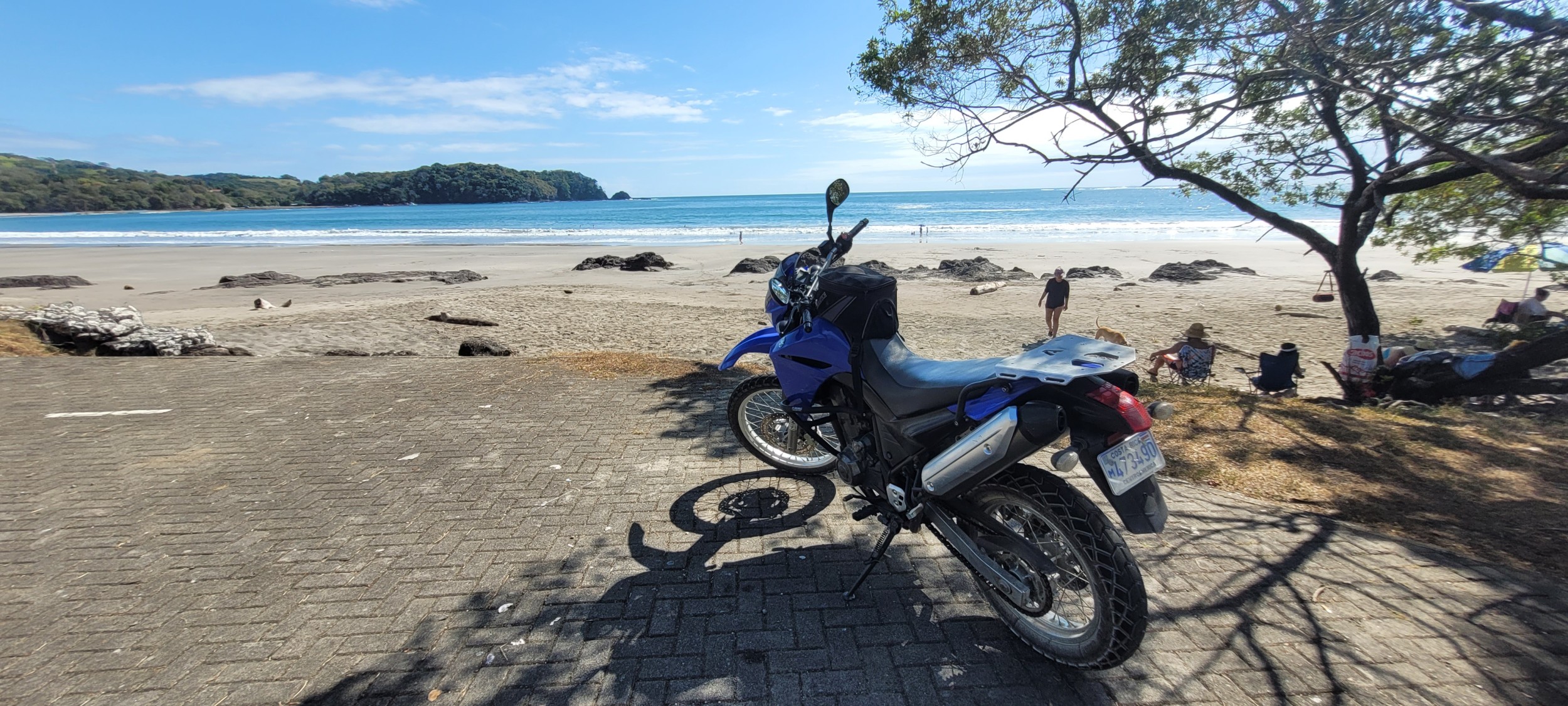 Motorrad in vordergrund un blaue himmel in hintergrund, strand und sonneschein