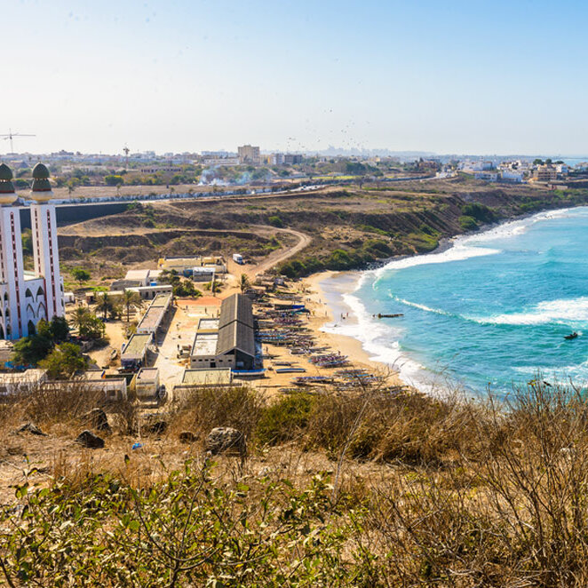 Luftaufnahme einer Moschee mit zwei Minaretten und einem Sandstrand an der Küste