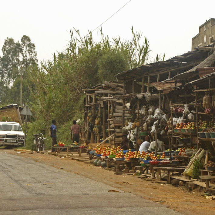 Rote Lateritpiste durch grüne Hügel in Uganda