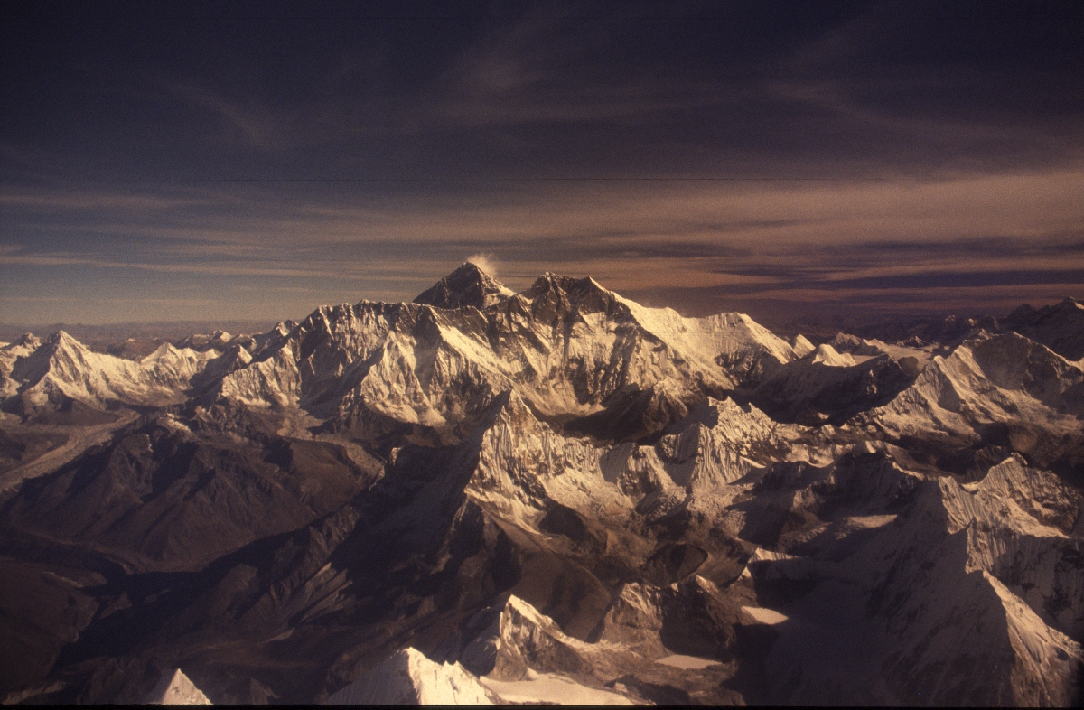 Vista aérea de picos nevados do Himalaia a brilhar ao entardecer