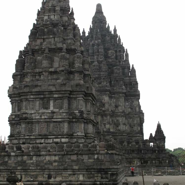 Hohe steinerne Türme des Tempelkomplexes Prambanan unter bewölktem Himmel