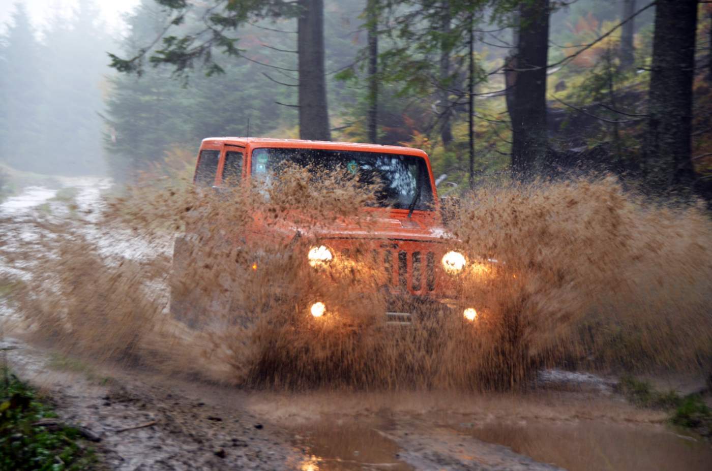 Mit dem Jeep durch Schlammpfützen in den Wäldern der Karpaten Mit dem Jeep durch Schlammpfützen in den Wäldern der Karpaten