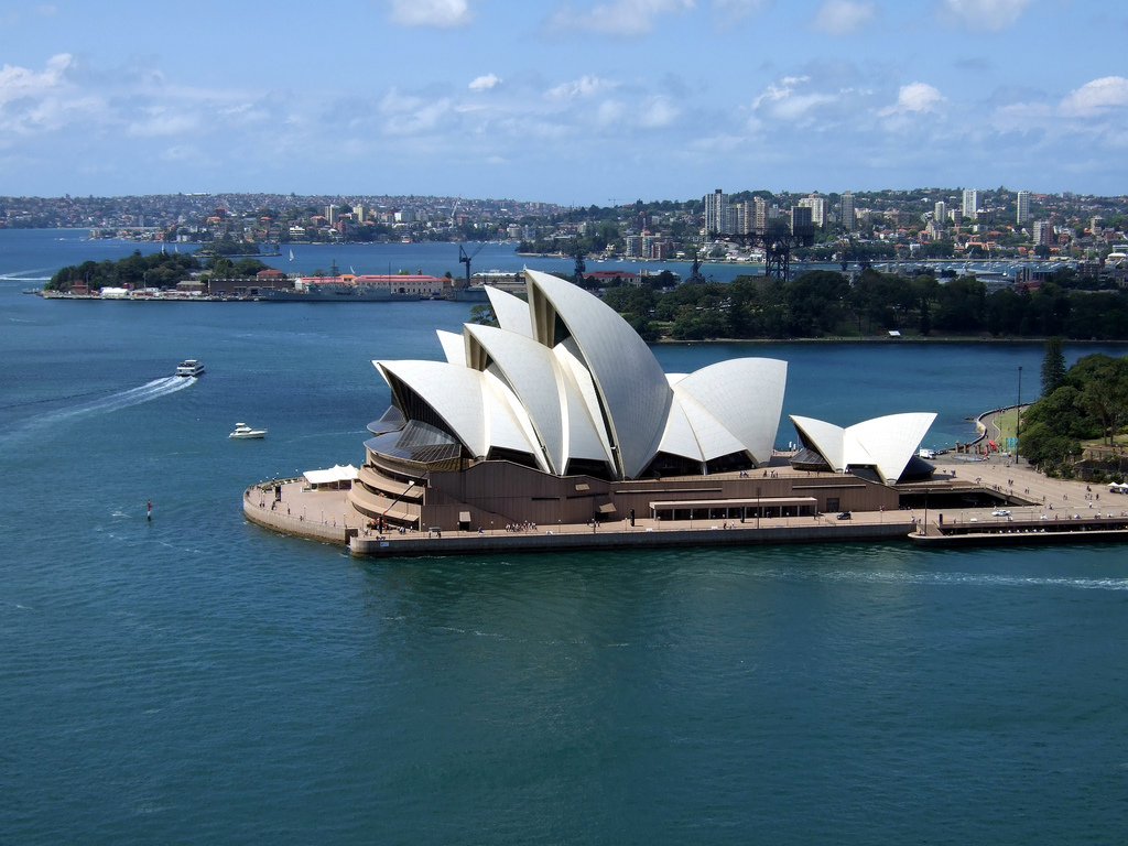 Luchtfoto van het Sydney Opera House en de haven, met de skyline van de stad erachter