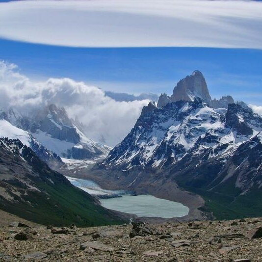 Zerklüftete schneebedeckte Gipfel des Fitz-Roy-Massivs erheben sich über einem türkisfarbenen Gletschersee