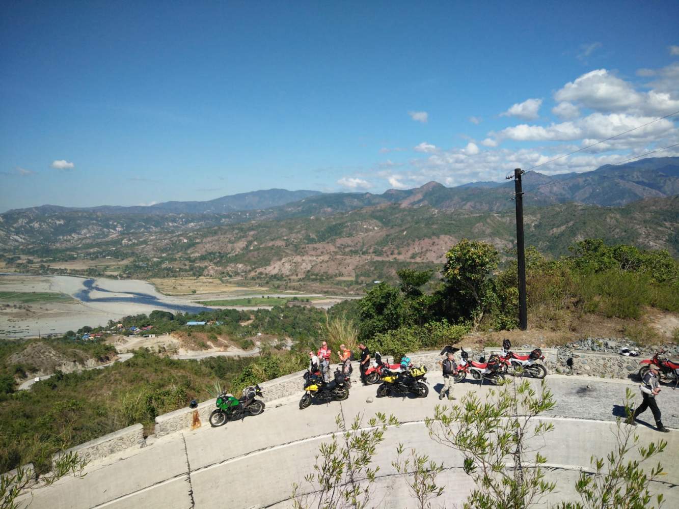 In der Gruppe auf dem Motorrad unterwegs im Norden von Luzon. Auf wunderschönen kurvigen Straßen genießen wir die Aussicht auf Berge und kleine Dörfer. Fotostopps sind auf der Philippinen Motorradreise unverzichtbar.