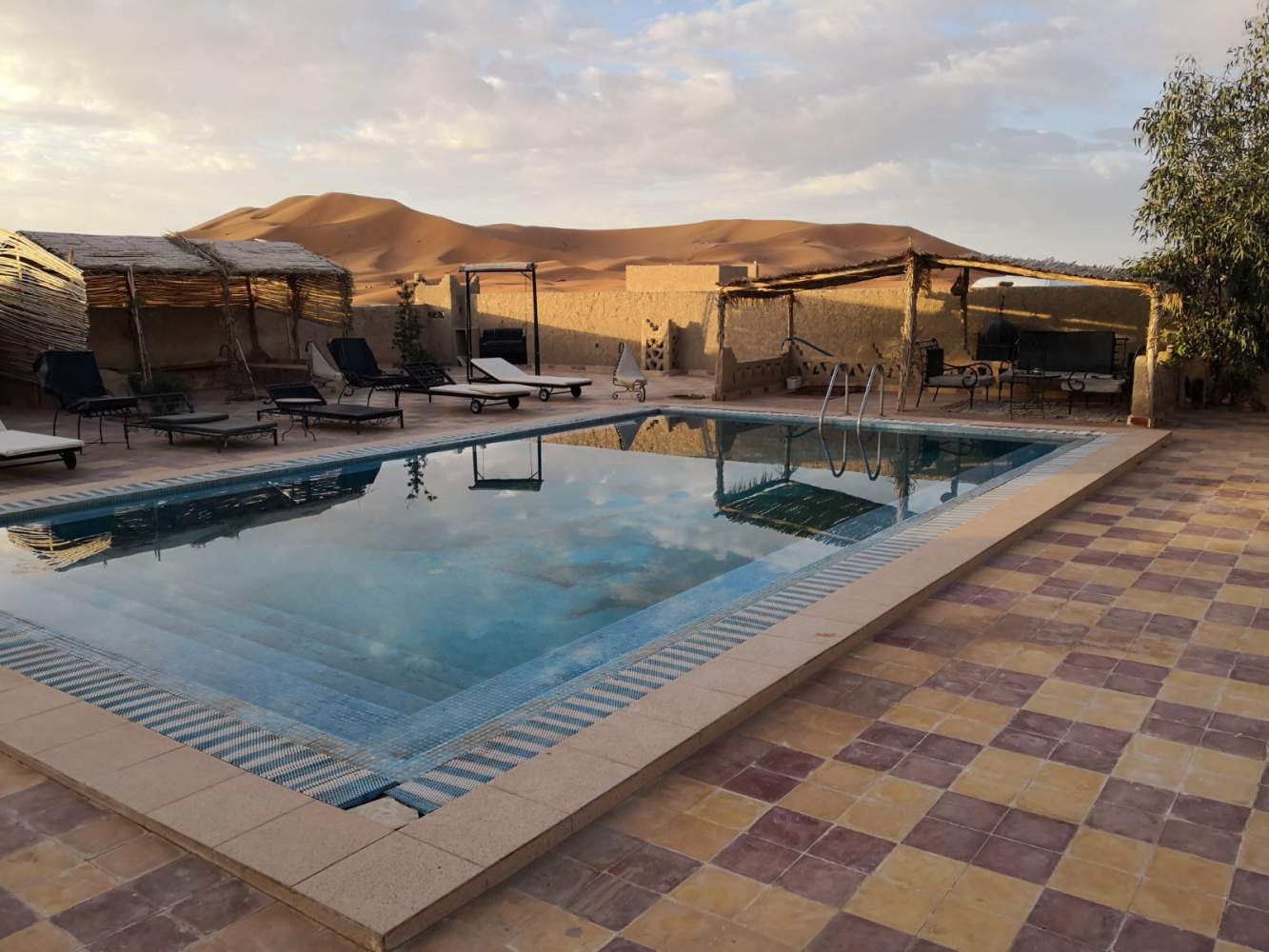 Swimmingpool im overlander camp Sahara Garden mit Blick auf die hohen Dünen des Erg Chebbi