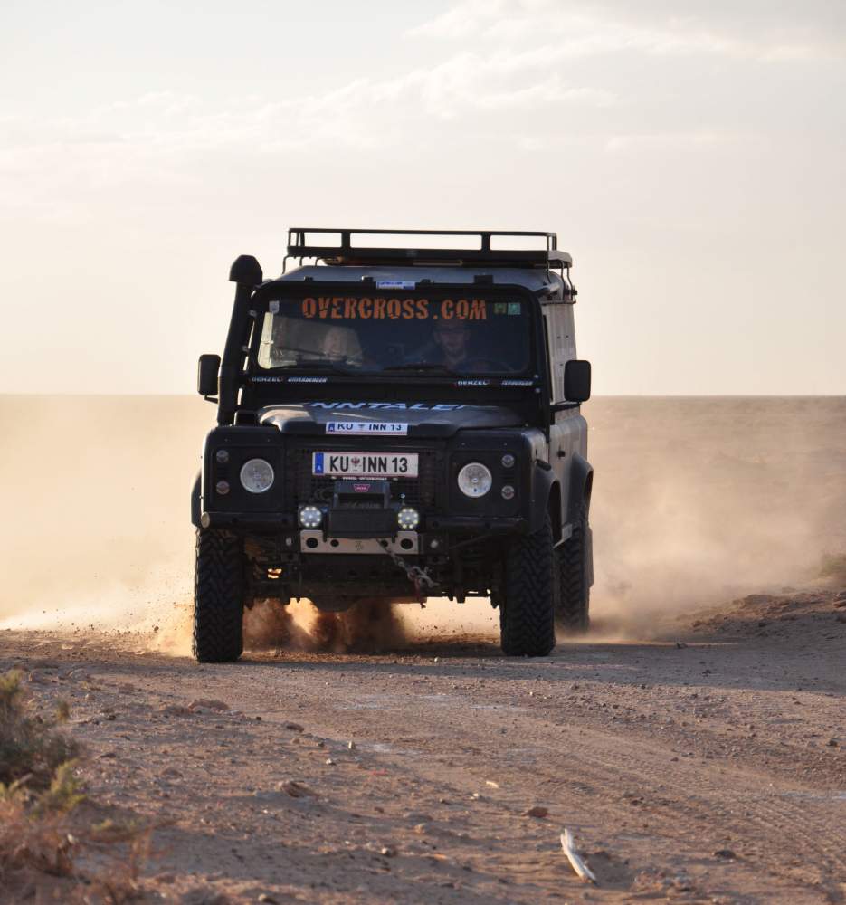 Land Rover Defender driftet über Schotterpiste in Tunesien