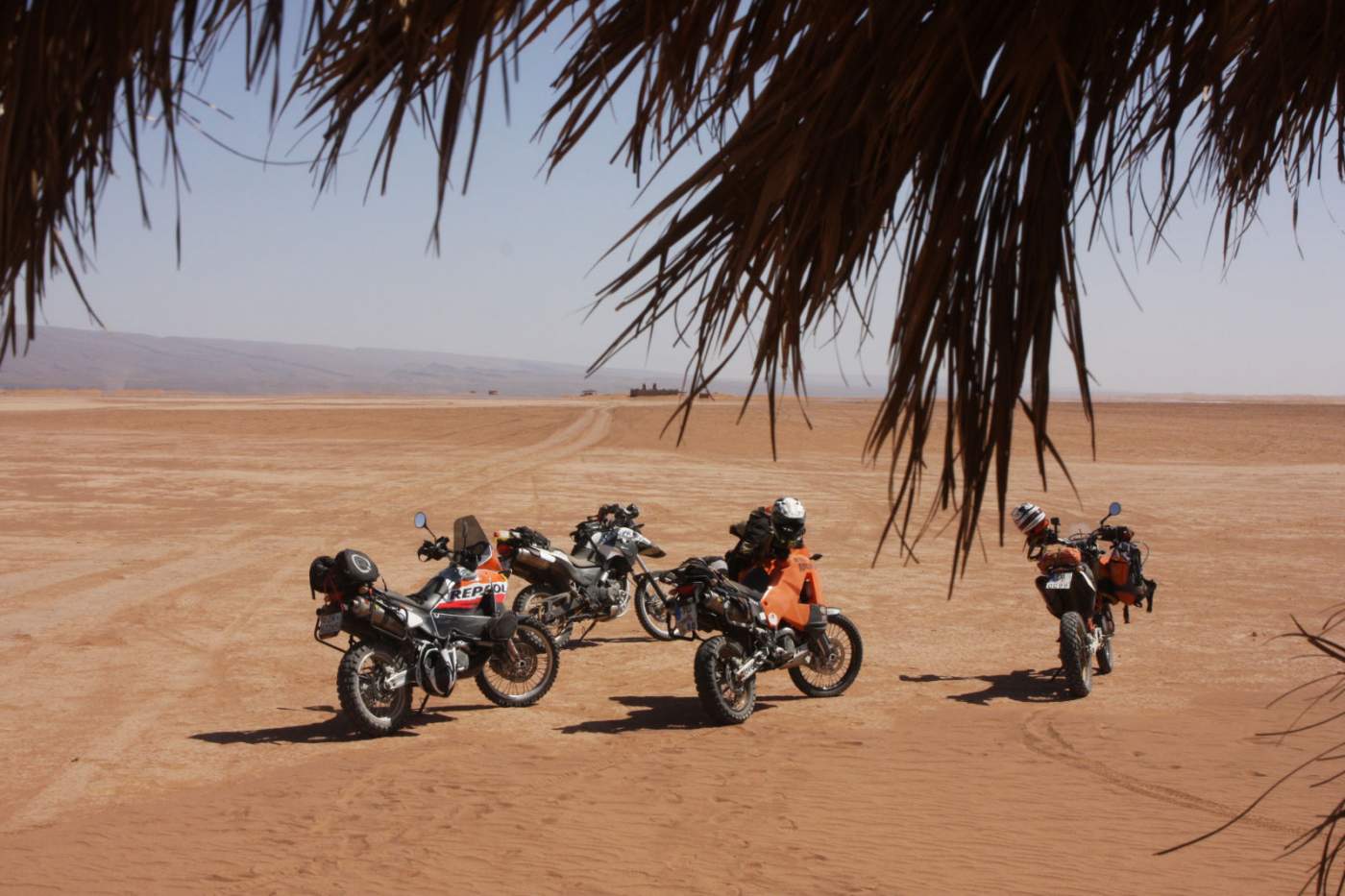 Reise Enduros von den Marokko Motorradreisen vor dem Wüstencafee auf dem ausgetrockneten Salzsee nahe dem Wüstenstreifen Erg Chigaga 