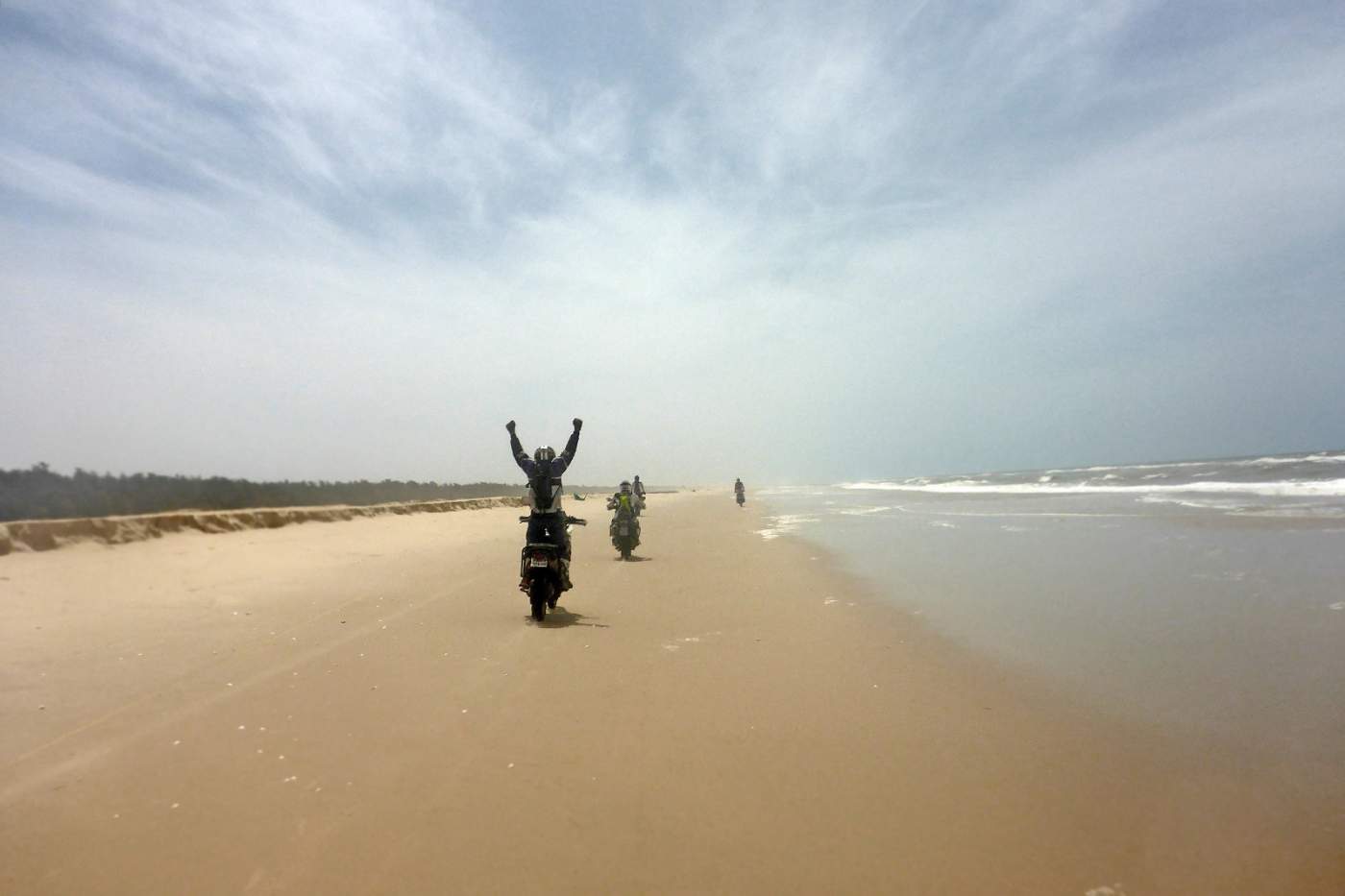 Motorradfahrer fahren auf dem Strand an der Küste Senegals auf der Motorradreise Paris Dakar