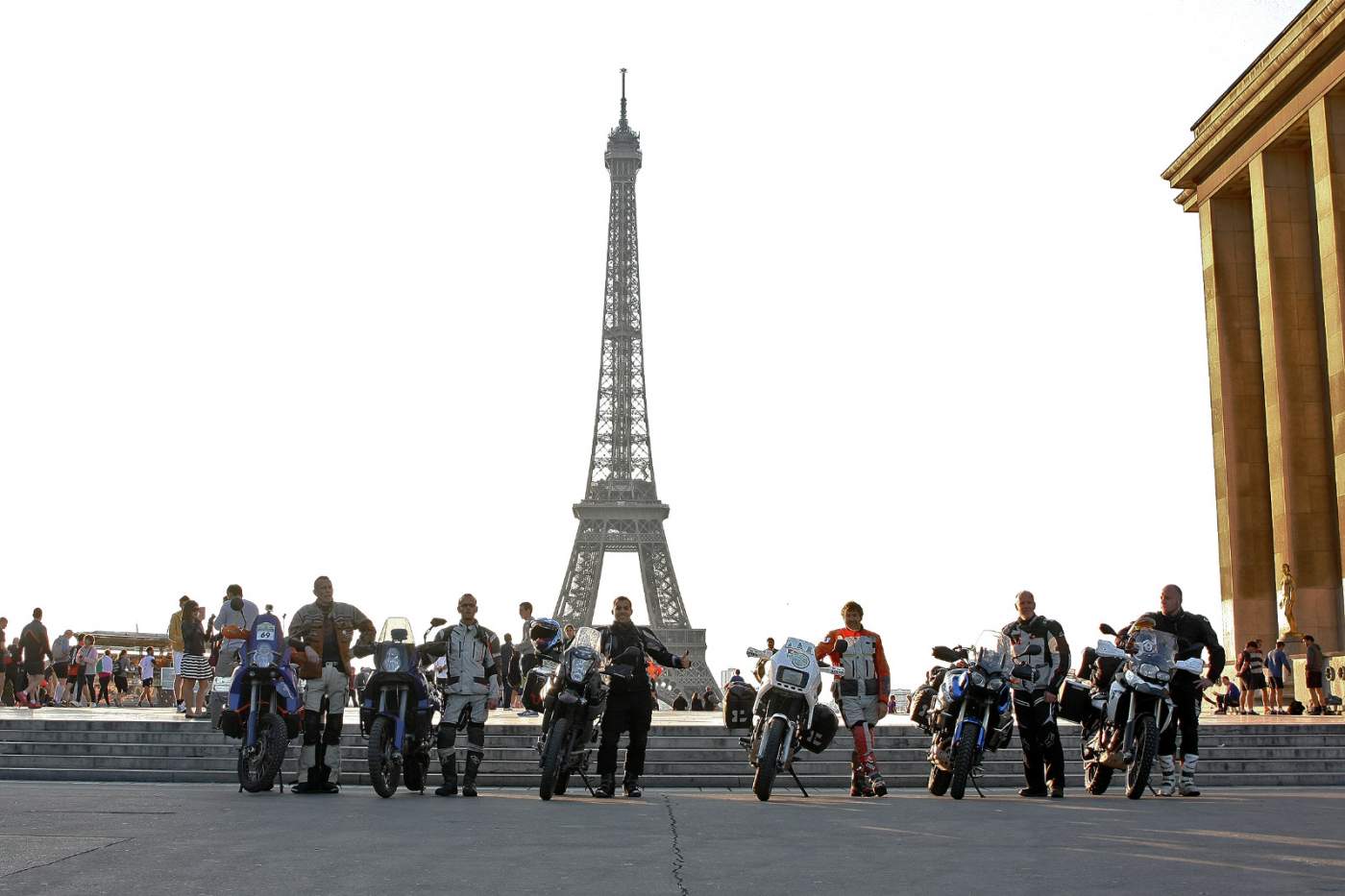 Motorradfahrer stehen aufgereiht vor dem Eifelturm